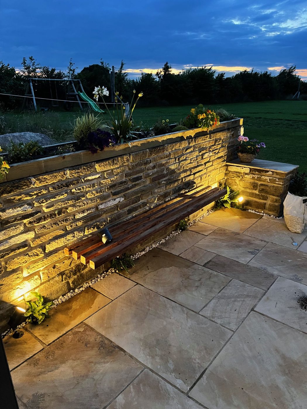 Dry stone wall with timber bench at dusk